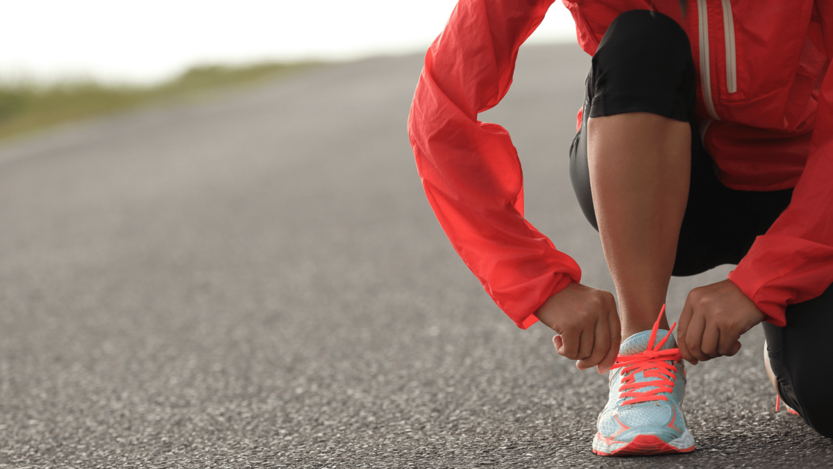 Blog content photo for Wellness Action Item: Exercise. Photo depicts a person putting on running shoes.