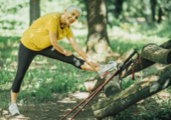 Blog header photo for Wellness Action Item: Exercise. Photo depicts a person stretching outside in preparation to exercise.